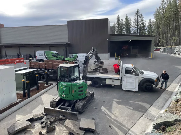 A track loader loading a Bay Area Demo and Hauling truck with broken pieces of cement